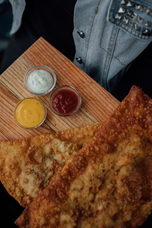 Crispy fried pastry with three dipping sauces on wooden board.の写真素材