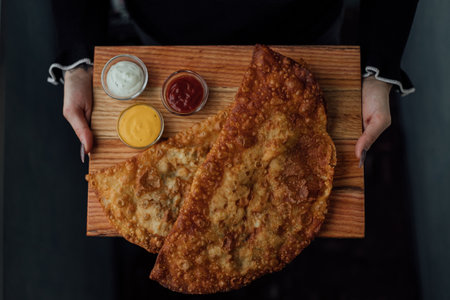 Delicious crispy pastry with assorted dipping sauces on wooden board.の写真素材