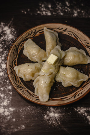 Traditional homemade dumplings with butter on rustic plate.の写真素材