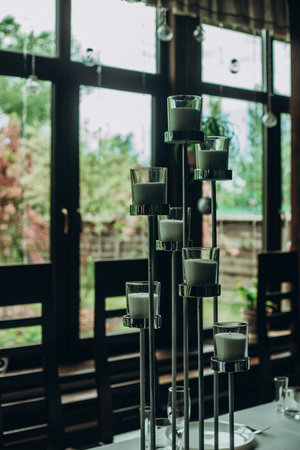 Elegant candle holder centerpiece in modern dining room with large windows.の写真素材