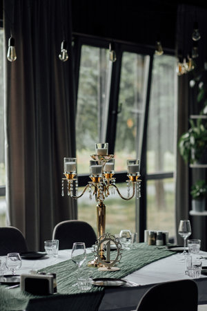 Elegant table setting with gold candelabra and crystal decor in sophisticated dining room.の写真素材