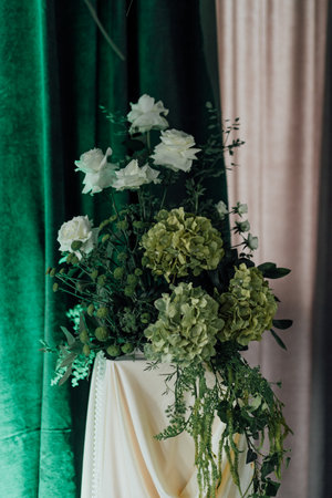 Elegant green and white floral arrangement with roses and hydrangeas.の写真素材