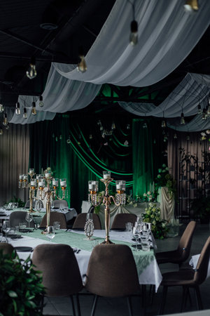 Elegant wedding reception with green decor and candlelit tables.の写真素材