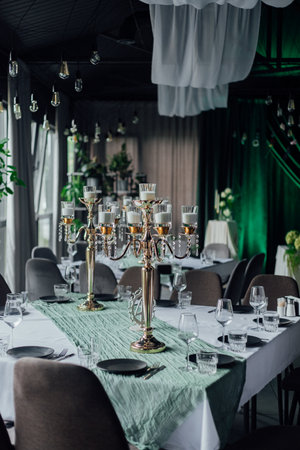 Elegant dining room with green accents and candelabras in a sophisticated setup.の写真素材