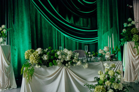 Elegant wedding reception table with green and white floral decorations.の写真素材