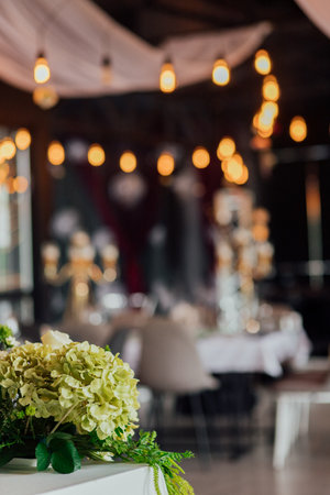Elegant indoor wedding reception with floral decoration and ambient lighting.の写真素材