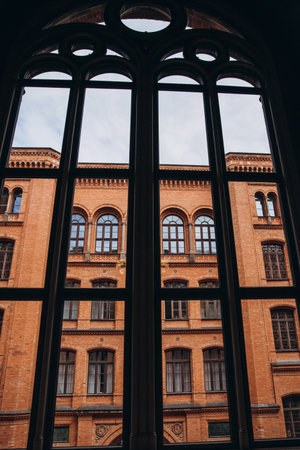 Gothic window overlooking a historic brick building facade.の写真素材