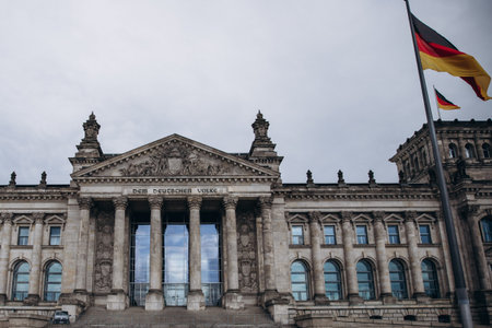 Historical architecture of the Reichstag building in Berlin with German flagsの写真素材