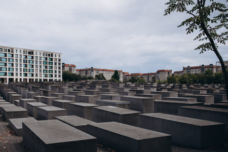 Holocaust memorial in Berlin with modern buildings and a cloudy skyの写真素材