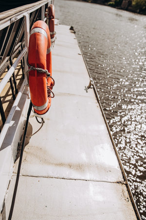Life preserver on a sunlit boat deck by the sparkling water