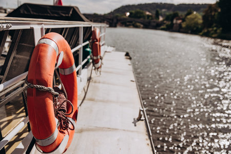 Lifebuoy on a boat deck by the shimmering river on a sunny dayの写真素材