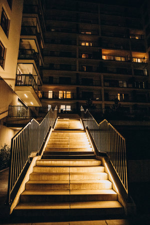 Illuminated staircase leading to a modern apartment building at night.の写真素材
