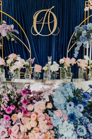Elegant floral arrangement with blue velvet backdrop and gold accents for a sophisticated event design.の写真素材