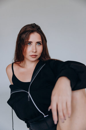 Woman in black outfit with contemplative expression indoors.の写真素材