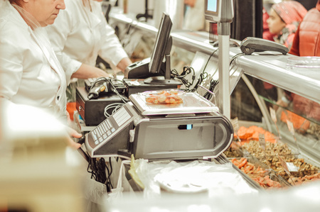 The seller behind the cash desk in the supermarketの写真素材