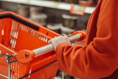 A woman's hand holding a shopping cartの写真素材