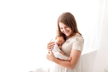 a newborn sleeps in his mother's arms, close-up, quiet sleep of the childの写真素材