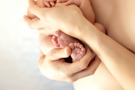 The father holds the newborn in his arms. Legs of a newborn in dad's hands, the concept of a happy...