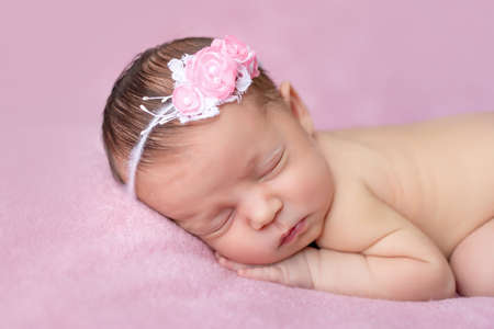 portrait of a newborn baby girl sleeping on a pink blanket background, place for text, healthy baby sleep.の写真素材