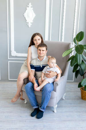 young mom and dad holding a child, parents with a child in a photo Studio, family dayの写真素材