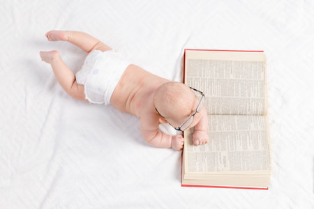 a baby with a book, a top view, the concept of training and development