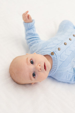 portrait of a baby boy on a bed. Textiles and bedding for children. Baby's morningの写真素材