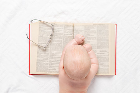 a baby with a book, a top view, the concept of training and developmentの写真素材