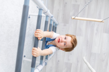 a child on the Swedish wall plays sports at home, a boy climbs a ladder with a rope, the concept of...