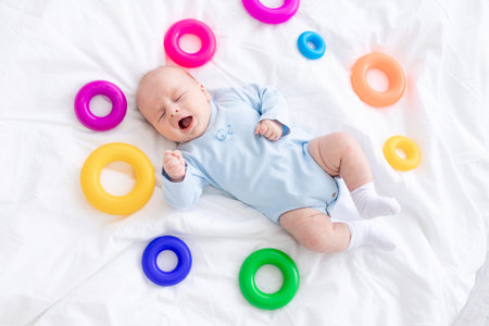 baby boy crying on bed among toys