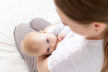 baby sucking breast, young mom breastfeeding baby, top viewの写真素材
