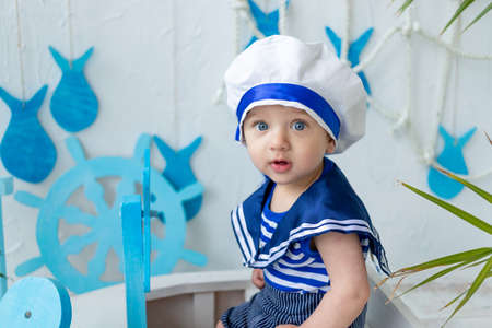 baby in the sea zone with a ship in a sailor's vest, the concept of summer and travelの写真素材
