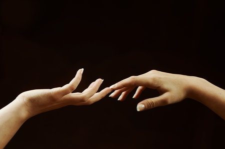 Sepia photo of two hands touching elegantlyの写真素材