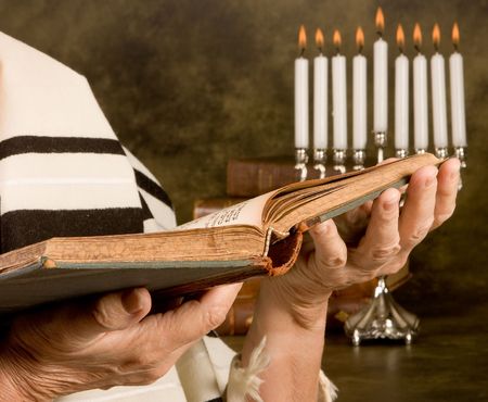 Hands holding a jewish prayer book wearing a prayer shawlの写真素材