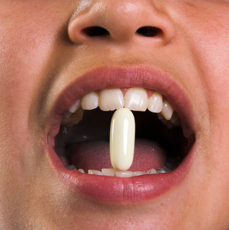 Close up of a pill in a boy's mouth