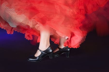Detail of the whirling skirt and stamping feet of a flamenco dancerの写真素材