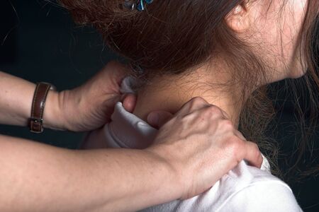 Young office woman getting a neck massage by a colleagueの写真素材