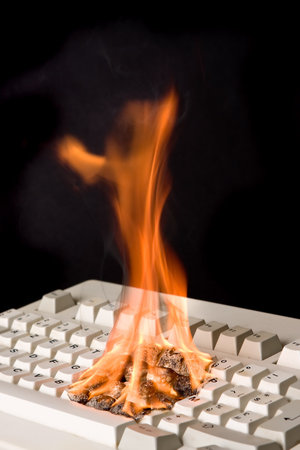 Old computer keyboard on fire due to fast typing?の写真素材