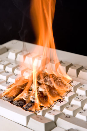 Closeup of an old computer keyboard on fireの写真素材