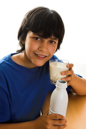 Boy with a milk mustache, toasting with a glass of milkの写真素材