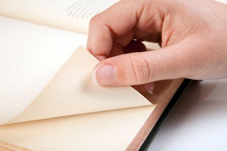 Female hand turning a page of an old bookの写真素材