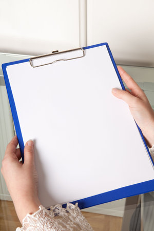 Female hands holding an empty clipboard with copyspace