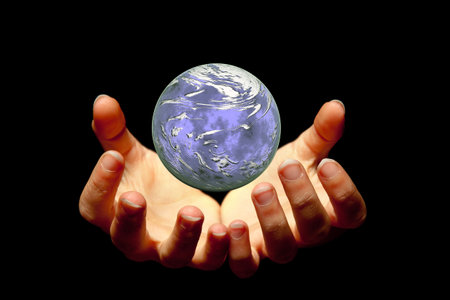 Female hands holding a brilliant globe in the dark
