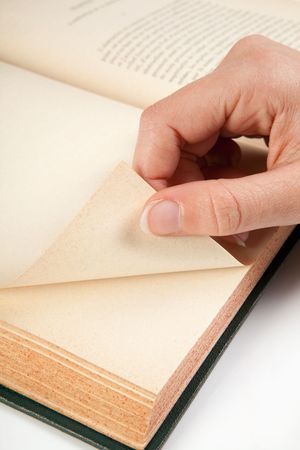 Female hand turning a page of an old bookの写真素材