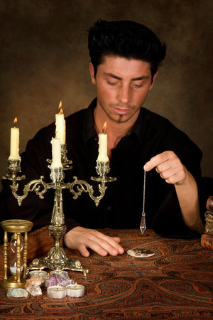 Fortune-teller holding a pendulum above a wedding photo (this photo is model released)