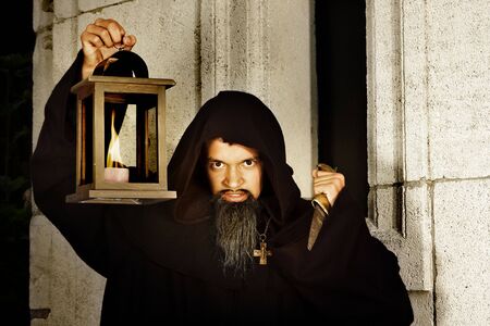 Halloween scene of an evil monk with dagger and lanternの写真素材