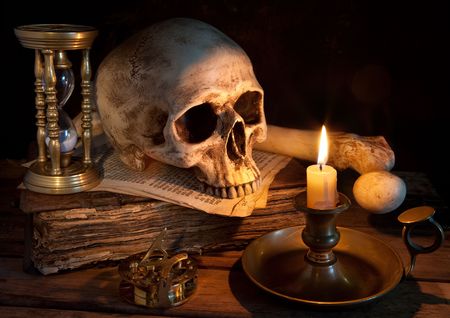 Vintage skull on antique book with candle and hourglassの写真素材