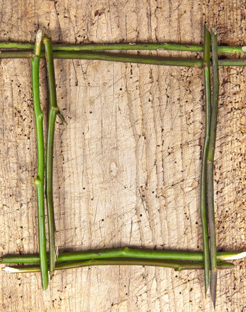 Border frame made of flower stalks on a wooden boardの写真素材