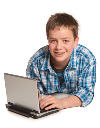 Teenager lying on the floor working on his laptop or netbook