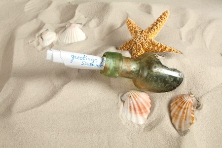Holiday greetings sent as a message in a bottle on a beachの写真素材
