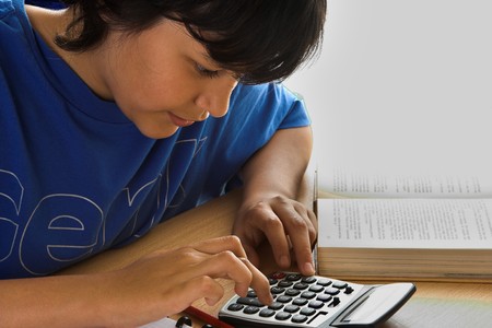 Boy doing his homework with a calculatorの写真素材